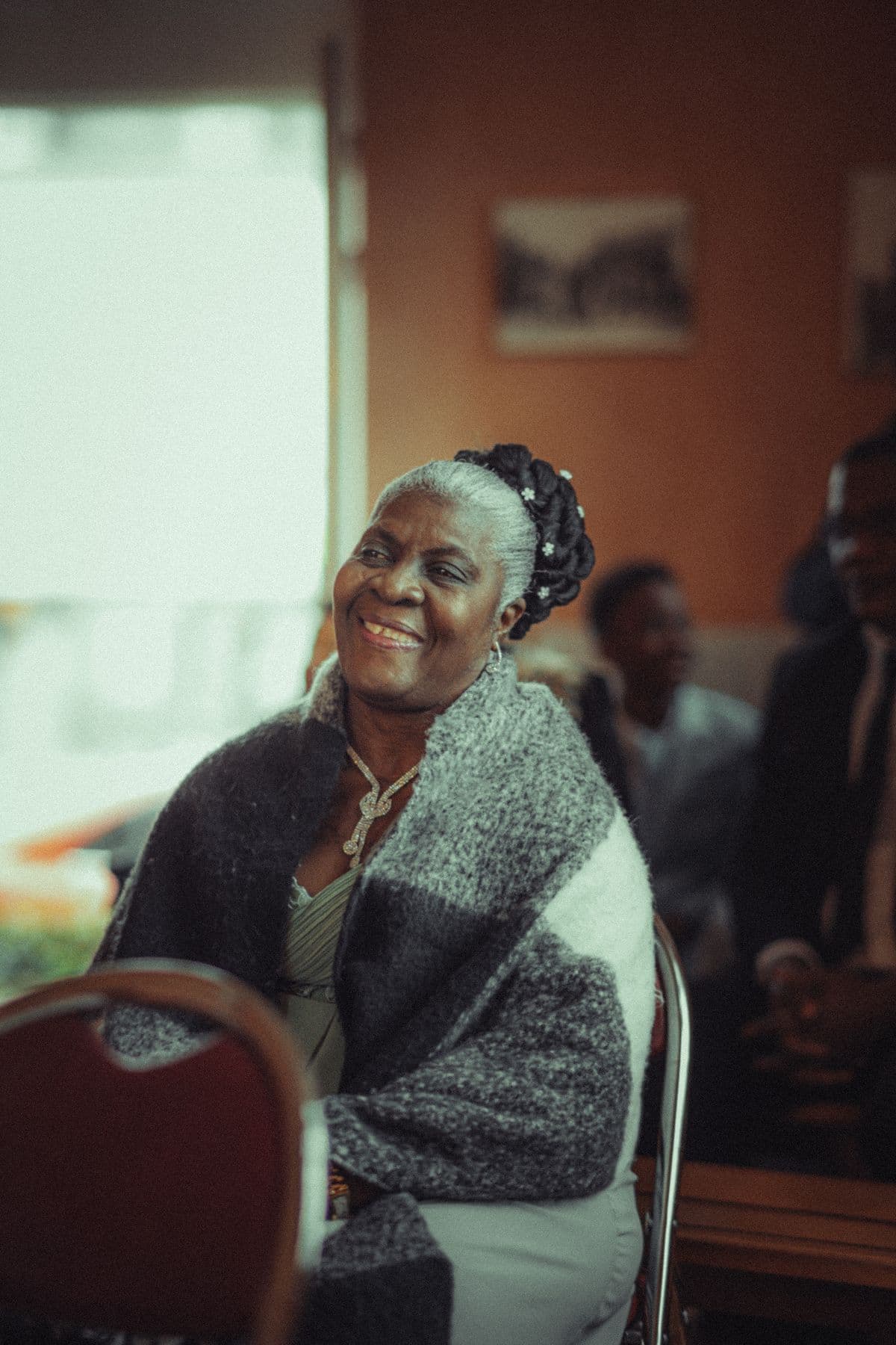 An older woman smiling warmly as she uses Amka on a tablet